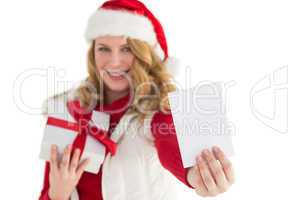 Festive blonde holding christmas gift and showing a card