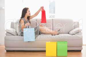Brunette sitting on the couch holding shopping bags