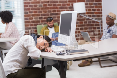 Casual young woman resting head on computer keyboard