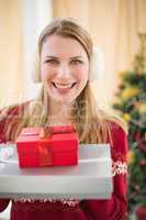 Smiling blonde wearing earmuffs while holding gifts