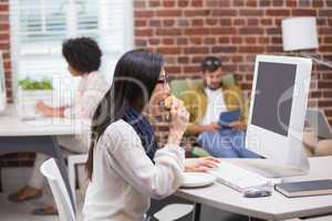 Casual woman drinking coffee while using computer