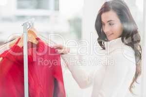 Pretty brunette looking at clothes on rail