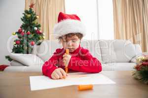 Festive little boy writing wish list