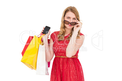 Cute woman holding shopping bags and her smartphone