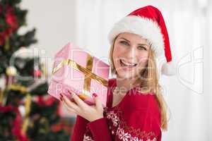 Smiling festive woman showing a pink gift