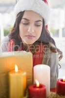 Portrait of a thoughtful brunette behind candles