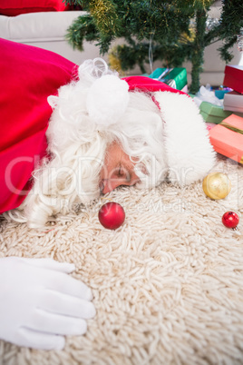 Exhausted santa sleeping on the rug