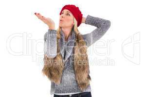 Blonde in winter clothes blowing kiss