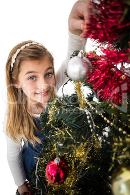 Festive little girl decorating christmas tree