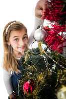 Festive little girl decorating christmas tree