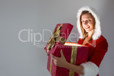 Festive pretty brunette opening a gift