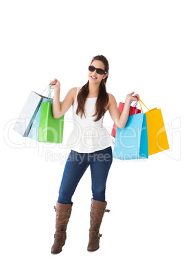 Cheerful brunette holding shopping bags