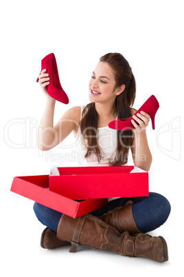 Content brunette holding red shoes