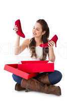 Content brunette holding red shoes