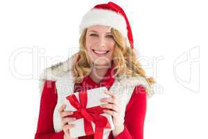 Smiling young woman in santa hat holding a gift