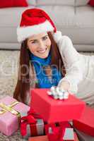 Festive redhead smiling at camera with gifts