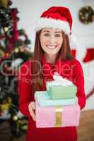Festive redhead holding christmas gifts