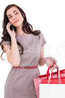Serious brunette with shopping bags on the phone