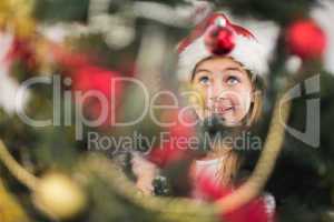 Festive litte girl decorating christmas tree