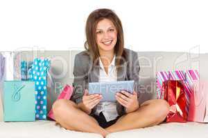 Beautiful woman on sofa with a tablet and credit card