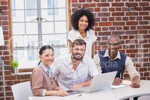 Creative business team using laptop in meeting