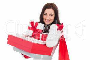 Joyful brunette holding christmas gifts and shopping bags