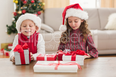 Festive siblings smiling at their gifts