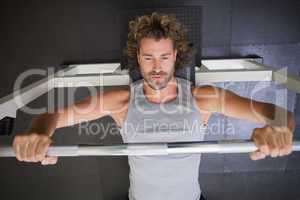 Muscular man lifting barbell in gym