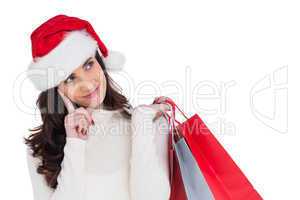 Festive brunette holding shopping bags and thinking