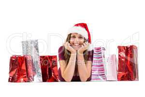 Festive brunette smiling at camera with gift bags