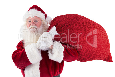 Santa carries his red bag and smiles