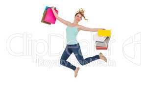 Excited blonde jumping while holding shopping bags