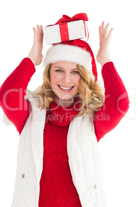 Smiling woman balancing christmas gift on her head
