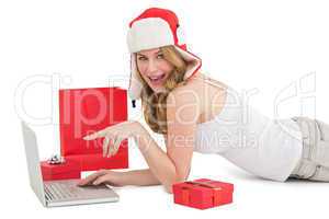 Happy woman laying on the floor while using her laptop