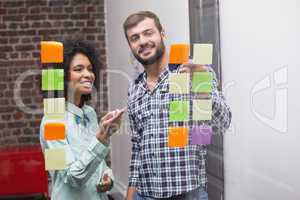 Business team looking at sticky notes on window