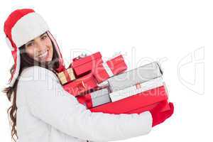 Festive brunette in winter clothes holding many gifts