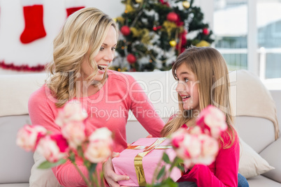 Little girl giving her mother a christmas gift