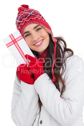 Festive brunette in winter clothes pointing gift