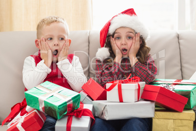 Festive siblings surrounded by gifts