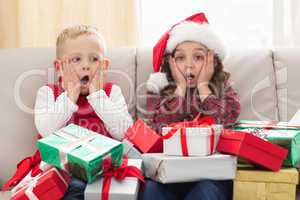 Festive siblings surrounded by gifts