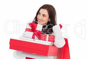 Happy brunette holding christmas gifts and shopping bags