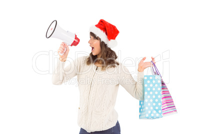 Festive brunette holding megaphone and bags