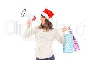 Festive brunette holding megaphone and bags