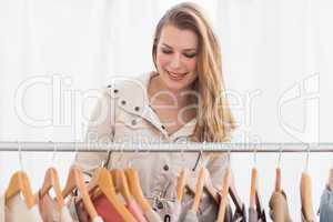 Pretty blonde looking through clothes rail