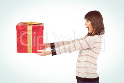 Surprised brunette holding a gift