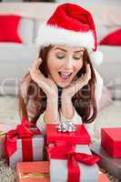 Festive redhead smiling at gifts