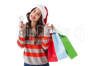 Smiling brunette holding credit card and shopping bags