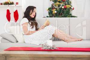 Relaxed brunette reading on the couch at christmas