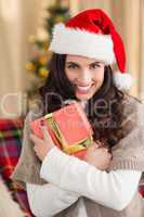 Festive brunette pressing gift at christmas