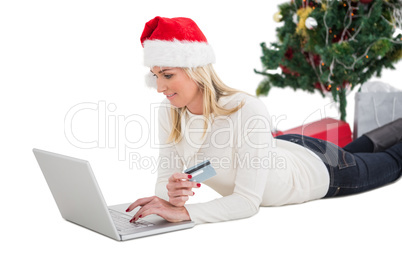 Festive blonde shopping online with laptop